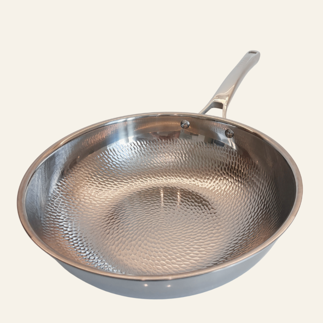 A hammered titanium wok frying pan with a long handle, shown from an elevated angle against a solid off-white background.