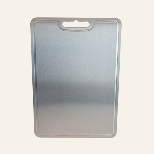 A rectangular metallic silver cutting board with a rounded handle cutout at the top, shown against a plain off-white background.